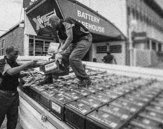 Battery Warehouse workers offloading batteries black and white